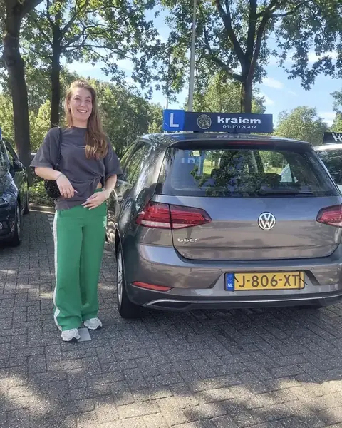 Leerling geslaagd voor haar rijbewijs naast de lesauto van Rijschool Kraiem in Tilburg